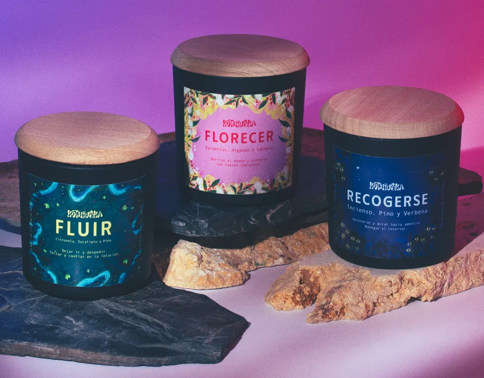 Three Kathiuska candles with illustrated labels on stone slabs