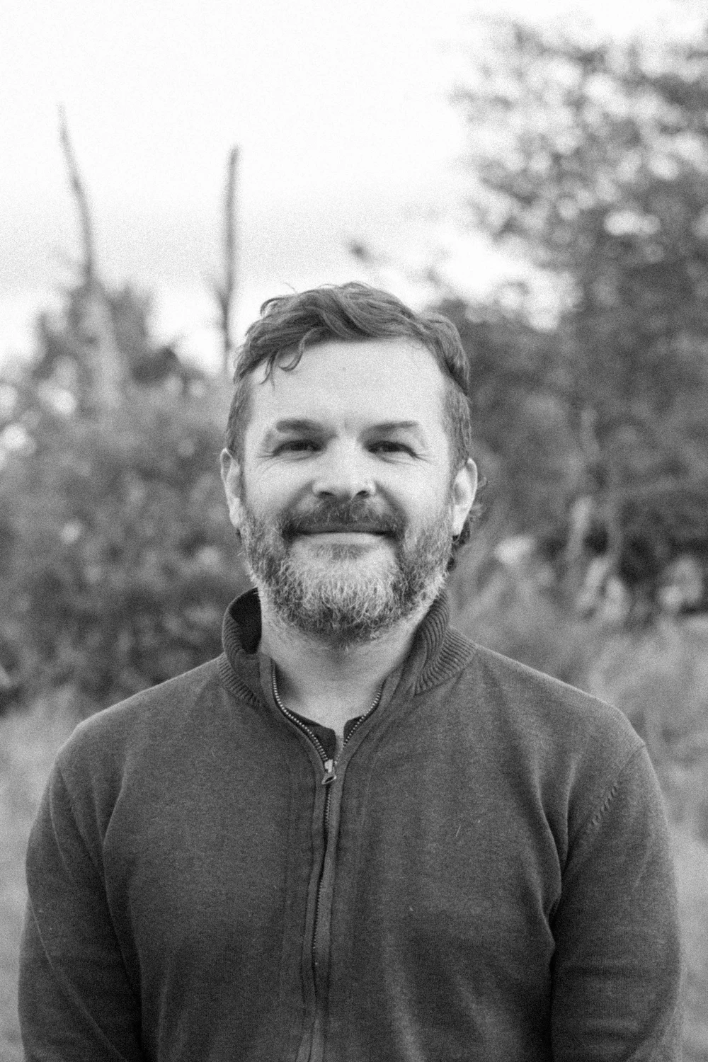 Retrato al aire libre de un integrante de Coocine con suéter oscuro, en blanco y negro