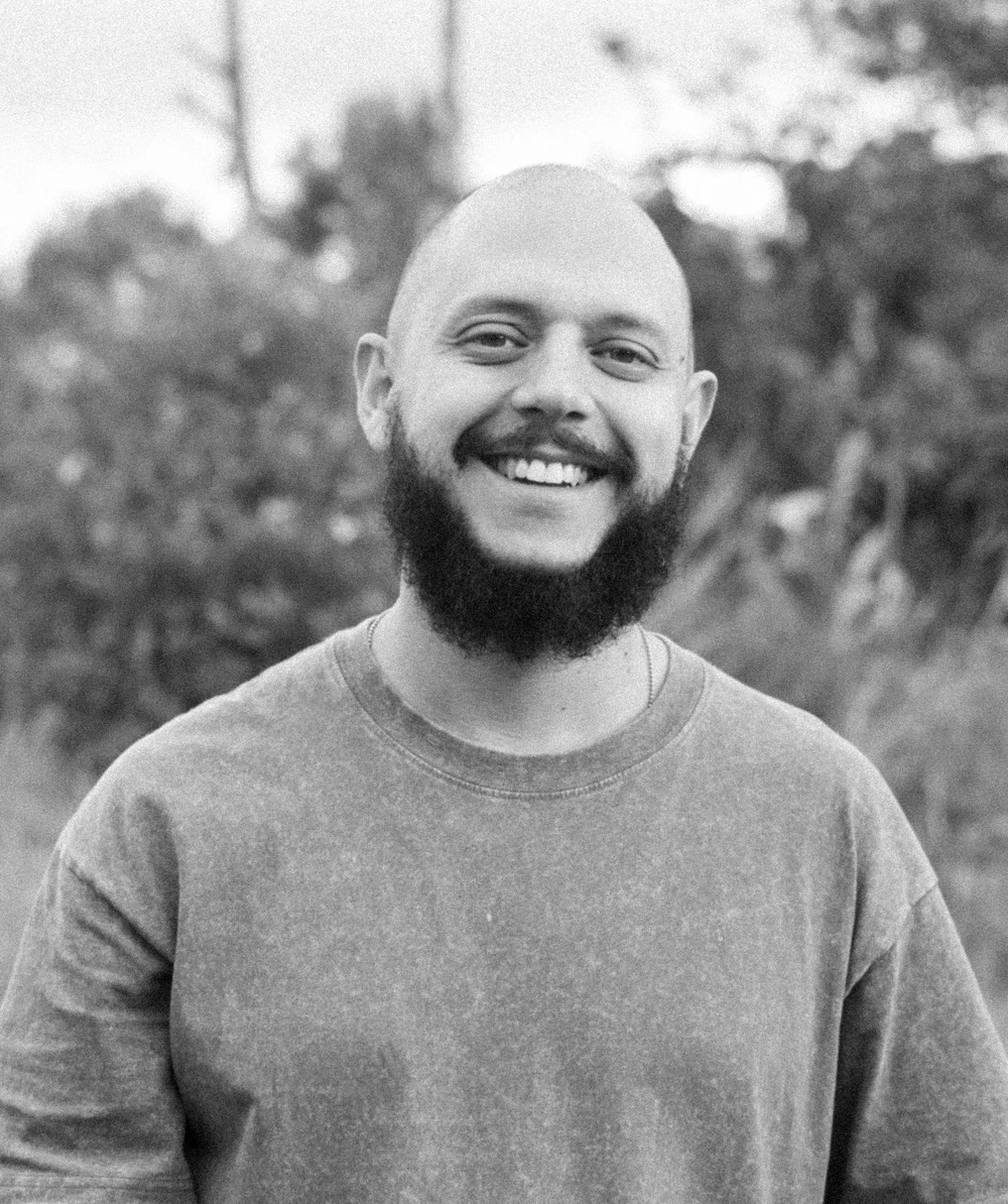 Retrato al aire libre de un integrante de Coocine con suéter claro, en blanco y negro
