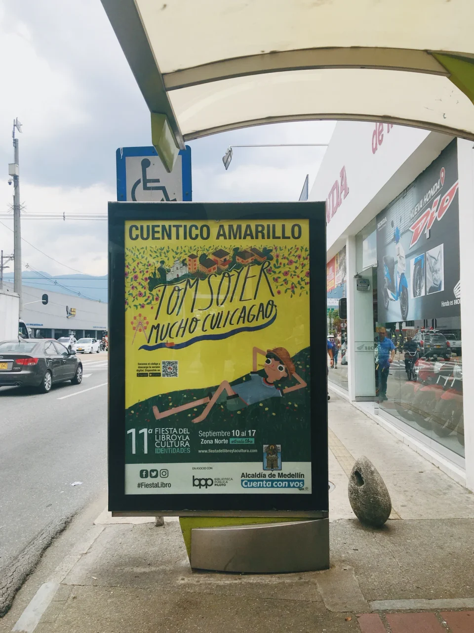 The Cuentico Amarillo poster on a street shelter in Medellín