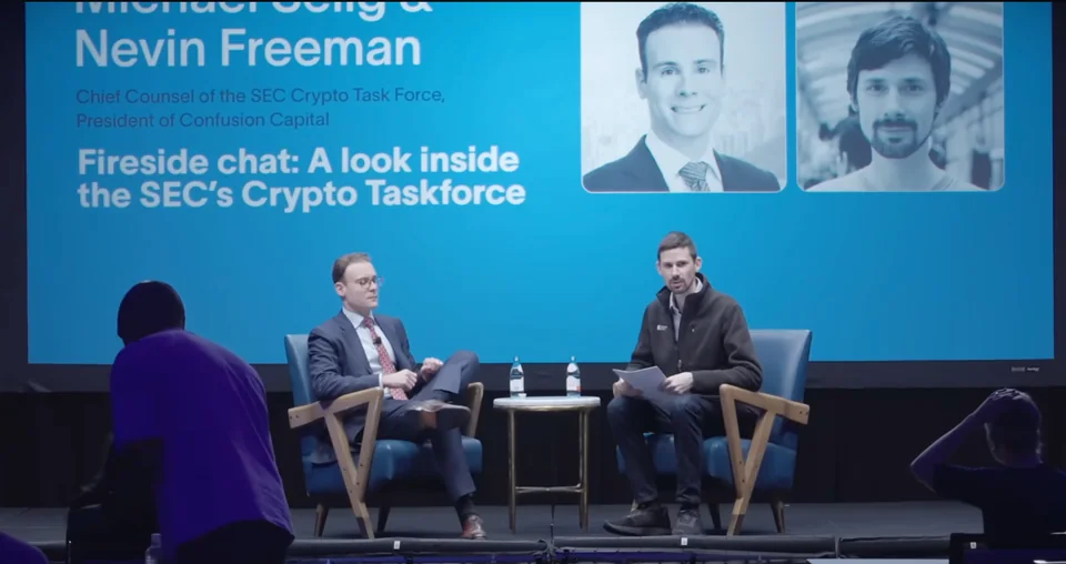 Monetarium 2 fireside chat: two speakers seated in front of the blue session screen